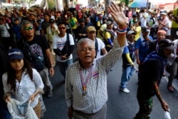 Anti-government protest leader Suthep Thaugsuban waves to his supporters as he leads a march in central Bangkok May 8, 2014.