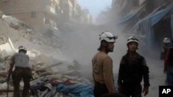 In this picture provided by the Syrian Civil Defense group known as the White Helmets, Syrian Civil Defense workers search through the rubble in rebel-held eastern Aleppo, Syria, Oct. 12, 2016. The situation in Aleppo is among the focal points of the Lausanne talks.