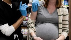 FILE - A pregnant woman receives a COVID-19 vaccination at Skippack Pharmacy in Schwenksville, Pa., Feb. 11, 2021.