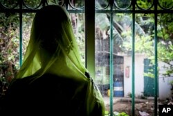 Diakite, 46, looks out the window after her annual check up with Dr. Abdoul Aziz Kasse at the Clinique des Mamelles in Dakar, Senegal on July 13, 2017. Diakite has successfully recovered from cervical cancer thanks to Dr. Kasse and yearly checks.