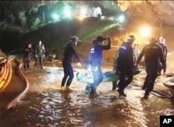 This undated from video released via the Thai NavySEAL Facebook Page, July 11, 2018, shows rescuers hold an evacuated boy inside the Tham Luang Nang Non cave in Mae Sai, Chiang Rai province, in northern Thailand.