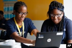Jahiem Johnson, 13, left, helps classmate Kamya Saunders, 13, as they work on an English passage during class at the Washington Leadership Academy in Washington, Aug. 23, 2017. The school utilizes "personalized learning."
