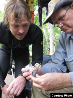 Co-principal investigator Michael R. Waters and CSFA student Morgan Smith examine a biface, or bifacial stone tool, in the field after its discovery. (A. Burke/CSFA)