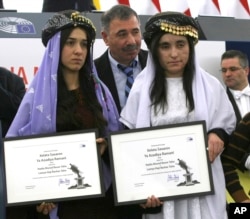Yazidi women from Iraq, Nadia Murad, left, and Lamiya Haji Bashar, pose with their award after receiving the European Union's Sakharov Prize for human rights at the European Parliament in Strasbourg, France, Dec. 13, 2016.
