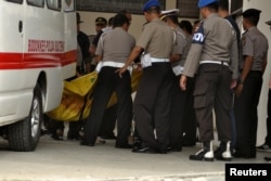 Polisi membawa kantong jenazah, salah satunya diyakini berisi jenazah Santoso, militan paling dicari di negara ini, di Palu, Sulawesi Tengah, 19 Juli 2016.