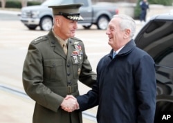 FILE - Chairman of the Joint Chiefs Gen. Joseph Dunford, left, shakes hands with Secretary of Defense James Mattis as Mattis arrives at the Pentagon, Jan. 21, 2017.