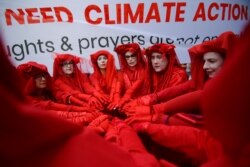 kelompok yang menamakan diri mereka "Red Rebels from Extinction Rebellion" berpartisipasi dalam aksi solidaritas di luar kantor Partai Liberal Australia di Sydney, Australia, 29 November 2019.