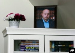 A portrait of Yalqun Rozi is seen atop a bookcase in his son and wife's apartment Thursday, April 18, 2019, in Philadelphia. (AP Photo/Jacqueline Larma)