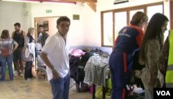 Volunteers help the newly-arrived migrants at the Cergy-Pontoise recreation center, Sept. 11, 2015. (Photo: L. Bryant for VOA)