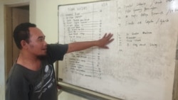 Fatkhul Khoir dari KontraS Surabaya menunjukkan daftar pengunjuk rasa RUU Cipta Kerja yang diamankan polisi, di Surabaya, Jawa Timur, Kamis, 15 Oktober 2020. (Foto: Petrus Riski/VOA)