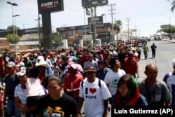 Central American migrants traveling with the annual migrant Stations of the Cross caravan march for migrants' rights and protest the policies of U.S. President Donald Trump, in Hermosillo, Mexico, Monday, April 23, 2018.