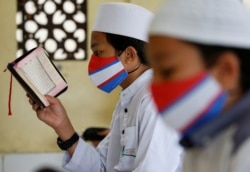 Siswa Muslim mengenakan masker wajah di tengah penyebaran COVID-19, saat membaca Alquran di Masjid Al-Kautsar Daarul Qur'an selama bulan suci Ramadhan, di Bogor, Jawa Barat, 9 Mei 2020 . (Foto: Reuters/Willy Kurniawan)