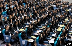 Members of the Thai parliament representing the military-backed Palang Pracharath party raise their hands, approving the nomination of Prayuth Chan-ocha as Thailand's prime minister during a session in Bangkok, Thailand, June 5, 2019.