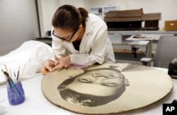 In this Aug. 31, 2017, photograph, conservator Kathryn Etre repairs an exhibit as work continues on the Museum of Mississippi History and the Mississippi Civil Rights Museum in Jackson, Mississippi