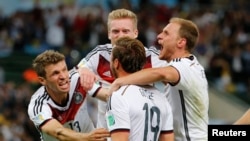 Germany's Mario Goetze (C) celebrates with teammates after scoring against Argentina during extra time in their 2014 World Cup final at the Maracana stadium in Rio de Janeiro July 13, 2014.