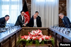 FILE - U.S. Secretary of State Mike Pompeo, left, Afghan President Ashraf Ghani, center, and Afghan Chief Executive Abdullah Abdullah, right, arrive for a meeting at the Gul Khanna in the Presidential Palace in Kabul, Afghanistan, July 9, 2018.