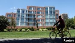 A cyclist makes his way past a building in Alexandria, Virginia, Aug. 9, 2017, that contains a unit listed to Paul Manafort, President Donald Trump's former campaign manager, whose residence was raided by the FBI on July 26 as part of a special counsel's investigation.
