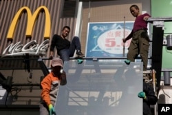 Workers install glass panels near a McDonald's in Beijing, Nov. 7, 2017. U.S. President Donald Trump is in Beijing amid mounting U.S. trade complaints, with limited prospects for progress on market access, technology policy and other sore points.