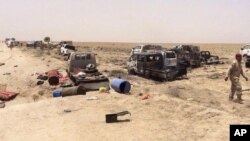 FILE - Iraqi security forces inspect vehicles belonging to escaping Islamic State militants outside Fallujah, Iraq, Wednesday, June 29, 2016.