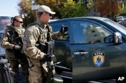 FILE - Fighters from the Azov volunteer battalion arrive on rotation from the front line in Kyiv, Ukraine, Sept. 15, 2014.