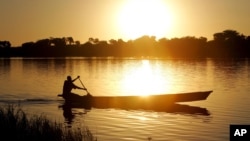 FILE - A fisherman rows a canoe on Lake Chad, in Koudouboul, Chad, Nov. 25, 2006.
