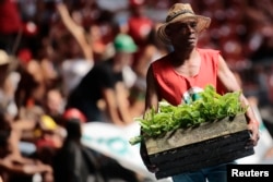 FILE - A member of the Landless Workers Movement attends the opening ceremony of its 6th National Congress in Brasilia, Brazil, Feb. 10, 2014.