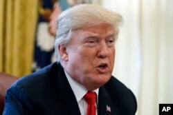 President Donald Trump speaks with reporters in the Oval Office of the White House in Washington, Dec. 22, 2017.