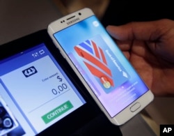FILE - A Samsung employee demonstrates Samsung Pay using a Galaxy S6 Edge Plus in New York, Aug. 6. 2015.