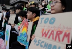 Students hold signs during a rally for global climate strike for future in Seoul, South Korea, March 15, 2019.
