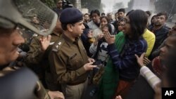 An Indian woman, right, part of a group demonstrating against the brutal gang-rape of a woman on a moving bus, argues with police officers after they were prevented from protesting in New Delhi, India, Dec. 24, 2012.