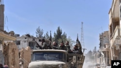 Syrian soldiers celebrate their victory against the Islamic State group in Qaryatain, Syria, April 4, 2016.