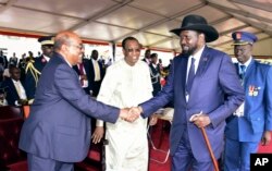 President Omar al-Bashir of Sudan, left, and President Salva Kiir of South Sudan shake hands during the inauguration ceremony of Uganda's long-time president Yoweri Museveni in the capital Kampala, May 12, 2016.