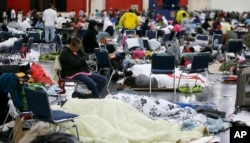 People rest at the George R. Brown Convention Center that has been set up as a shelter for evacuees escaping the floodwaters from Tropical Storm Harvey in Houston on Tuesday, Aug. 29, 2017.