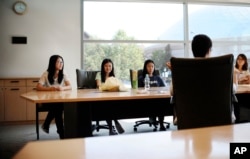 FILE - University of Connecticut sophomore Anyi Yang of Beijing, left, attends a meeting of the Chinese students and scholars association on campus in Storrs, Conn., Sept. 18, 2015. A surge of students from China is leading U.S. universities to confront the challenges of integrating them more into American campus life.