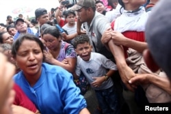 A Honduran migrant, part of a caravan trying to reach the U.S., cries after others stormed a border checkpoint in Guatemala, in Ciudad Hidalgo, Mexico, Oct. 19, 2018.