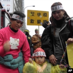 蓝屿原住民黄美娇(左)带着孩子参加游行