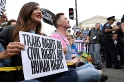 LGBT activists and supporters block the street outside the U.S. Supreme Court as it hears arguments in a major LGBT rights case.