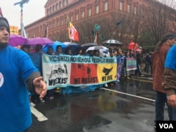 A volunteer controls the crowd as protesters prepare to march from the Army Corps of Engineers’ headquarters. (E. Sarai/VOA)