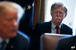 FILE - National security adviser John Bolton listens as President Donald Trump speaks during a cabinet meeting at the White House in Washington, April 9, 2018.