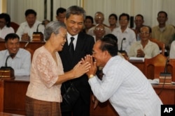 នាយក​មជ្ឈមណ្ឌល​ឯកសារ​កម្ពុជា (DC-Cam) លោក ឆាំង យុ និង​ម្តាយ គឺ​លោកស្រី​ កែវ ណន ជួប​ជាមួយ​មេឃុំ ហុង ហ៊ុយ និង​អ្នកស្រុក​អ្នកភូមិ​មក​ពី​ឃុំ​ព្រះនេត្រព្រះ​ កាលពី​ឆ្នាំ​២០១២ ដើម្បី​ចូលរួម​ស្តាប់​សវនាការ​ តុលាការ​កាត់ទោស​មេដឹកនាំ​ខ្មែរ​ក្រហម។ (រូបថត៖ AP)