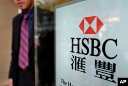 FILE - A man walks out from an HSBC branch office in Hong Kong. Mainland China’s growing influence over the city and recent political demonstrations may have discouraged the bank from shifting its headquarters from London to Hong Kong.