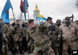 Mykola Kokhanivsky, commander of a volunteer battalion, throws a stone against the window of an office that belongs to Ukraine tycoon Rinat Akhmetov in Kyiv, Feb. 20, 2016. The activists blame Akhmetov for supporting corruption and pro-Russian separatists