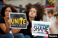 Two woman hold protest signs in support of Philando Castile during a rally on the capitol steps after a jury found St. Anthony Police Department officer Jeronimo Yanez not guilty of second-degree manslaughter in the death of Castile, in St. Paul, Minnesota.