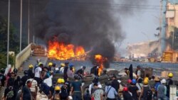 Anti-coup protesters take cover at a barricade as they clash with security forces on Bayint Naung Bridge in Mayangone, Yangon, Myanmar March 16, 2021. REUTERS/Stringer
