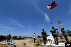 A FFILE - Filipinos conduct a flag raising ceremony at Pag-asa Island in the Spratly Islands