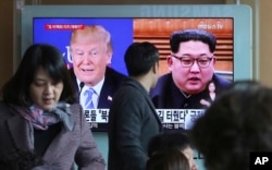 A man watches a TV screen showing file footage of U.S. President Donald Trump, left, and North Korean leader Kim Jong Un during a news program at the Seoul Railway Station in Seoul, South Korea, Monday, April 9, 2018.