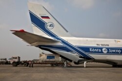 Staf darat dan awak pesawat Antonov An-124 Ruslan membongkar tanker Linde setibanya di Bandara Internasional Netaji Subhas Chandra Bose (NSCBIA) di Kolkata, India, 2 Mei 2021.