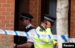 A police officer stands outside a property being searched after a man was arrested in connection with an explosion on a London Underground train, in Stanwell, near Heathrow airport, Britain, Sept. 17, 2017.