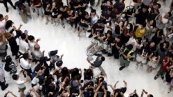 A man holds up a tuba as protesters shout slogans and sing Hong Kong's anthem during a protest at New Town Plaza shopping mall in Hong Kong, China September 11, 2019.