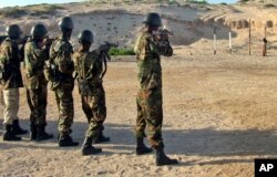 FILE - Somali government forces at a police center in Mogadishua's Hamar Jajab district prepare to shoot a former soldier who was found guilty of intentionally shooting and killing another soldier, June 4, 2011.